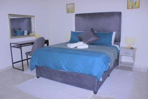 Villa Central في فرانسیستوون: غرفة نوم بسرير ازرق ومكتب