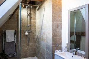 un bagno con doccia e lavandino di The Church Barn a Stratford-upon-Avon Altre 15 foto
