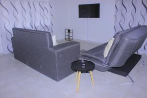 a living room with two chairs and a table at Villa Central in Francistown