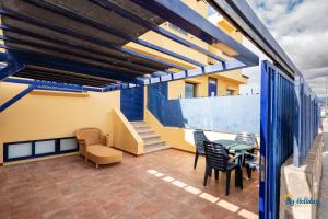 d'un balcon avec une table, des chaises et des escaliers. dans l'établissement Villa Meloneras III, à Maspalomas