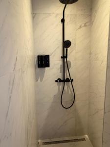 a shower with a shower head in a bathroom at Maastricht Suites - City Studio A in Maastricht