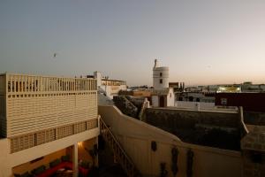 an aerial view of a city with a lighthouse at Riad Mazal Mogador in Essaouira