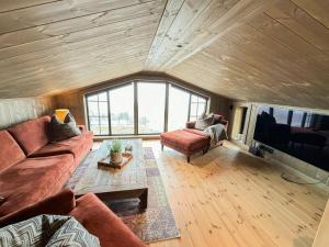 a living room with a couch and a tv at Architect Mountain Cabin At Lygna With Views in Jaren