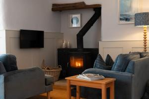 een woonkamer met banken en een houtkachel bij 70 Trefusis in Flushing