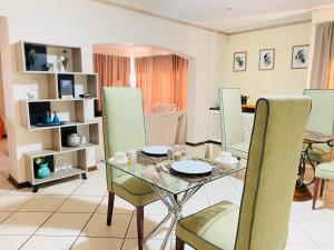 a dining room with a glass table and chairs at Siena Sun Celebration House Party friendly noise tolerant in Midrand