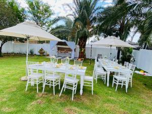 a white table with white chairs and umbrellas at Siena Sun Celebration House Party friendly noise tolerant in Midrand