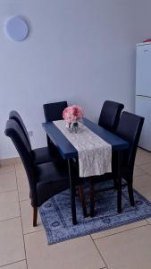 a dining room table with two chairs and a table with a flower on it at 2bed city centre apartment in Limerick