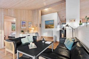 un soggiorno con un divano in pelle e un tavolo di BL1144-Blokhus-Sixtusvej-27 a Hune