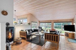 un soggiorno con divano e camino di BL1144-Blokhus-Sixtusvej-27 a Hune