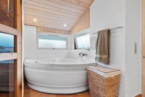 una grande vasca bianca in un bagno con finestra di BL1144-Blokhus-Sixtusvej-27 a Hune Altre 12 foto