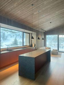 una cocina con una isla en el medio de una habitación en Architect Designed Mountain Cabin At Kvitfjell, en Favang 21 fotos más