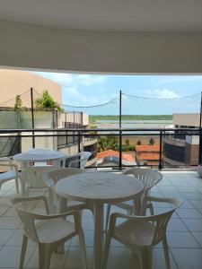 eine Terrasse mit Tischen und Stühlen auf einem Balkon in der Unterkunft Salinópolis Praia in Salinópolis