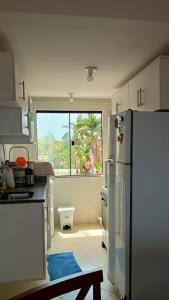 eine Küche mit einem Kühlschrank und einem großen Fenster in der Unterkunft Salinópolis Praia in Salinópolis