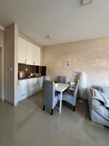 Novi BanovciにあるPrenočište Dunavのテーブルと椅子のあるキッチンとリビングルーム