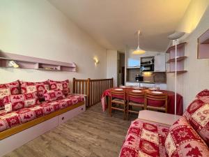 ein Wohnzimmer mit Couch und ein Esszimmer in der Unterkunft Résidence Grand Bois A1118 Clés Blanches in La Tania