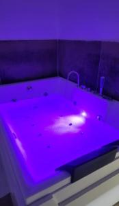 a bath tub with purple lighting in a room at Idromassaggio Room in Catania