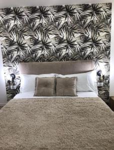 a bedroom with a large bed with a black and white wallpaper at Idromassaggio Room in Catania