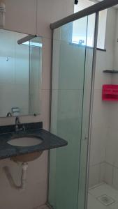 ein Badezimmer mit Waschbecken und Glasdusche in der Unterkunft Salinópolis Praia in Salinópolis + 28 Fotos