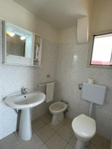 a white bathroom with a sink and a toilet at Villa Tony - Baia Verde Only Teenagers in Baia Verde