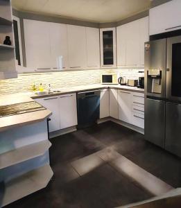 120n Villa Hietala paritalo, 1-8henkilön LUXUS majoitus, 3x160cm jenkkisängyt Löhösohvat, iso takaterassi, täyd keittiö Kodink, laatu sauna, Takka, Tv 75" x2, 2wc, autokatos, avainboxi koodilla, itsekirjaus 24h, wifi ja 500mb kuitunetti, kuivaava pesukone في سينايوكي: مطبخ بخزائن بيضاء وثلاجة سوداء