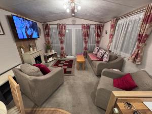 a living room with couches and a flat screen tv at Carnaby Rosedale in Crowle