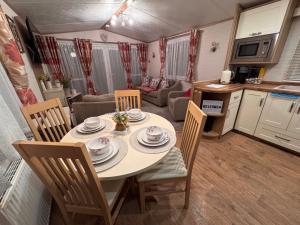 a kitchen and a dining room with a table and chairs at Carnaby Rosedale in Crowle