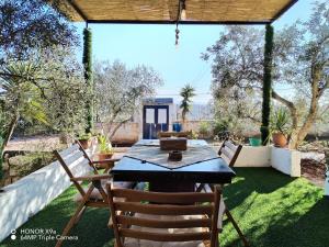 eine Terrasse mit Tisch und Stühlen auf dem Rasen in der Unterkunft Seleucia DaR Umm Qais in Um Qeis