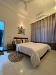 a bedroom with two beds and a window at Surf'n Lanka - Surf School in Weligama