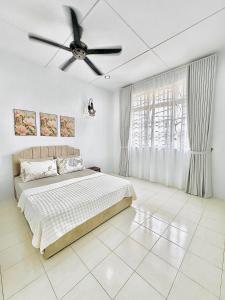 una camera da letto con un letto e un ventilatore a soffitto di Rumah Eve Taman Banting Baru Mvslim Only a Banting