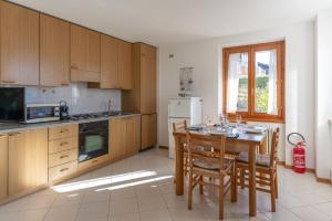 a kitchen with wooden cabinets and a table with chairs at Trilo La Rindela in Folgaria +19 photos