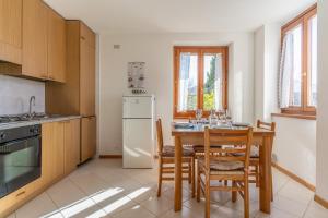 a kitchen with a table and a white refrigerator at Trilo La Rindela in Folgaria