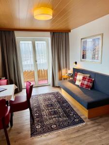 una sala de estar con un sofá y una mesa en Hotel Sonnenhof - bed & breakfast & appartements, en Innsbruck