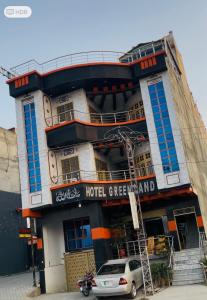 ein Hotel mit einem davor geparkten Auto in der Unterkunft Green land hotel in Mingora