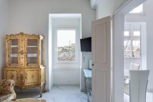 Valletta Townhouse Suite with a Maltese Balcony في إيل فورجانا: غرفة بها خزانة ذهبية ونافذة