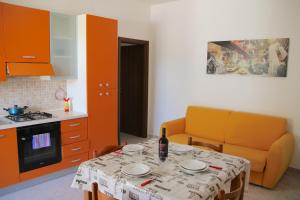 a kitchen with a table and a kitchen with orange cabinets at Villa Tony - Baia Verde Only Teenagers in Baia Verde