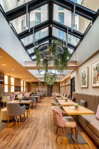 a restaurant with tables and chairs and windows at Point A Hotel London Shoreditch in London