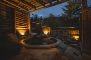 an outdoor hot tub in a backyard at night at 焼乃湯 in Takayama