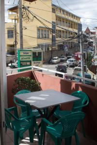 a table and chairs on a balcony with a view of a street at COCOONING HOME # Centre-Ville # Confort # Charmant # マダガスカルのゲストハウス in Antananarivo