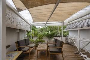 a patio with chairs and a table on a balcony at Le Flamboyant 309, magnifique appartement avec piscine in Saint-Gilles les Bains