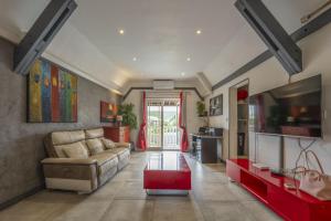 a living room with a couch and a table at Le Flamboyant 309, magnifique appartement avec piscine in Saint-Gilles les Bains