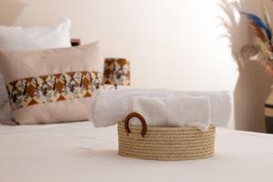 a basket filled with towels on a bed at COCOONING HOME # Centre-Ville # Confort # Charmant # マダガスカルのゲストハウス in Antananarivo