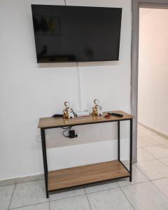 a table with a tv on top of a wall at Casa Little Italy in Boquerón