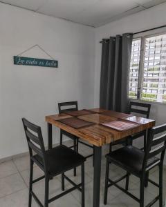 a wooden table and chairs in a room at Casa Little Italy in Boquerón