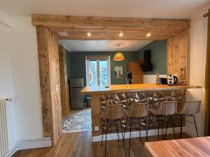 a kitchen with a bar with stools around it at Le Refuge de Raoul in Montier-en-Der