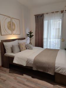 a bedroom with a large bed with a window at Luxury Spot Xanthi in Xanthi
