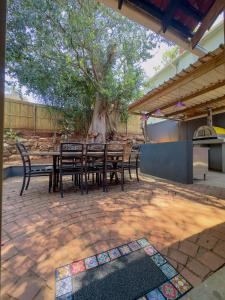 LadyBird Cottage في ديربان: طاولة وكراسي على فناء به شجرة