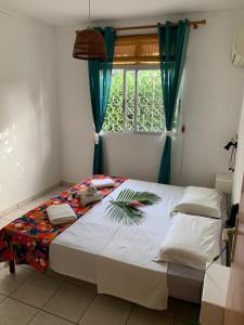 En eller flere senge i et værelse på Bungalow Corossol