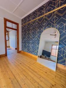 LadyBird Cottage في ديربان: غرفة فارغة بحائط مع مرآة +48 صورة