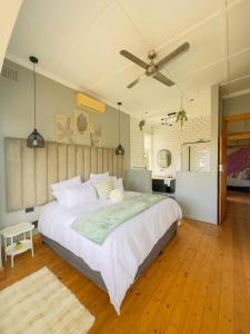 LadyBird Cottage في ديربان: غرفة نوم بسرير كبير مع مروحة سقف