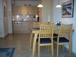 STR150b "Residenz Johannsens" F في نيندورف: مطبخ مع طاولة خشبية وكراسي وغرفة طعام